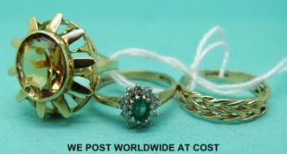 A 9ct gold ring set with an emerald surround by diamonds,