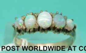 A yellow metal ring set with five opal cabochons (size N)