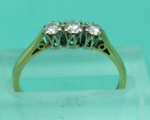 An 18ct ring set with three diamonds (size L)