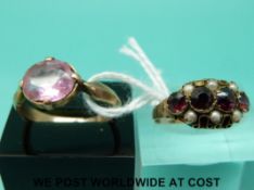 A 9ct gold ring set with garnets and seed pearls and a yellow metal ring set with a paste stone