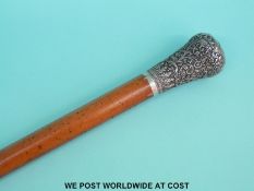 A Malacca walking cane with embossed white metal top decorated with lions and elephants,