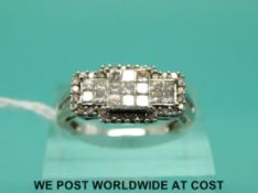 A 9ct white gold ring set with square and round cut diamonds in a cluster (size N)