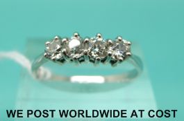 A white metal ring marked 18ct set with four old cut diamonds (size R)