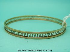 A 9ct gold bangle with pierced Greek Key design (7.