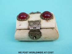 A small bone box set with red cabochons and brass clasps (length 6cm)