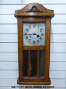 A c1910 light oak cased English wall clock, Arabic numerals on metal dial, large spade hands,