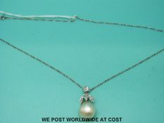 A platinum pendant set with a large baroque pearl and old cut diamonds, the largest approximately 0.