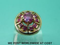 An 18ct gold ring set with pink sapphires in a circular setting with textured surround (size P)