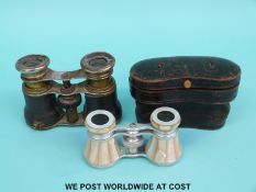 A cased pair of mother of pearl opera glasses and one other pair