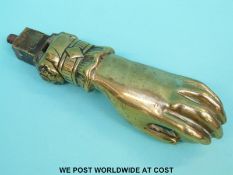 A Victorian brass door knocker in the form of a hand holding a ball (length 12cm)