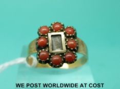 A Victorian ring with a glass compartment to the centre with plaited hair surrounded by coral