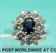 An 18ct white gold ring set with a sapphire surrounded by diamonds,