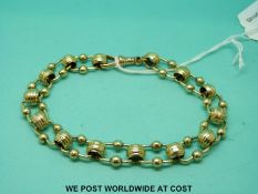 A Victorian yellow metal bracelet of barrel shaped links joined by sphere decoration (25.
