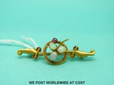 An Edwardian 15ct gold brooch set with three opals and a ruby