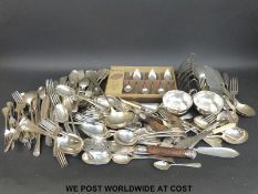 A large quantity of silver plated cutlery to include a quantity of rat tail design and a toast rack