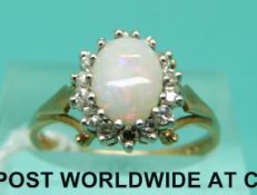 A 9ct gold ring set with an opal cabochon surrounded by diamonds,