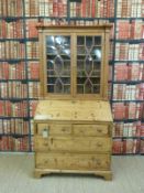 A 19thC pine astragal glazed bureau bookcase with two over two graduated drawers raised on bracket
