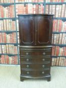 A reproduction drinks cabinet with brush slide and four bow fronted drawers (H130xW62xD42cm)