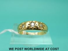 A yellow metal ring marked 18ct set with three diamonds in a star setting (size N)