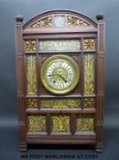 An aesthetic / Arts & Crafts clock with ceramic panels surrounding an enamel and gilt dial,