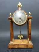 A French mantel timepiece in finialled drum case raised on plain pillars with brass decoration,
