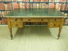 A 19thC leather inset pine twin pedestal desk raised on turned legs and brass castors