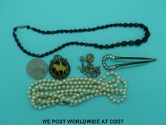 A large faux pearl necklace together with a paste set hair clip, a glass necklace,