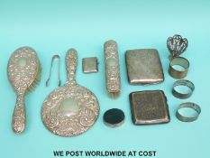 Two hallmarked silver cigarette cases, three silver napkin rings, sugar tongs and a vesta (339g),