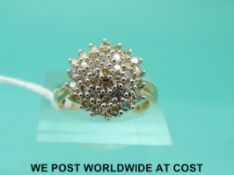 A yellow metal ring marked 9k set with diamonds in a cluster (size O)