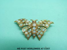 A 9ct gold brooch in the form of a butterfly or moth set with opals and with ruby eyes