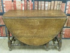 An oak drop leaf table with turned legs and stretchers (H77xW120xD168cm)