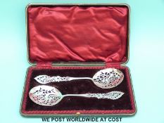 A cased pair of Edward VII hallmarked silver pierced and engraved sifter / serving spoons,