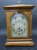 An oak cased German ting-tang bracket clock with silver chased dial, strike/silent subsidiary,