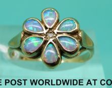 A 9ct gold ring set with a diamond to the centre surrounded by opals in a flower cluster (size O)
