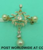 An Edwardian gold brooch in the form of a stylized cross set with old cut diamonds and pearls