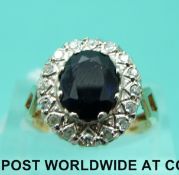 A 9ct gold ring set with an oval cut sapphire surrounded by diamonds (size O)