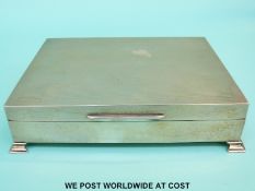 A large engine turned hallmarked silver cigarette case raised on four feet, Birmingham 1955,