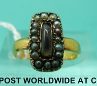 An 18ct gold Victorian mourning ring set with seed pearls and a glass section to the centre (size