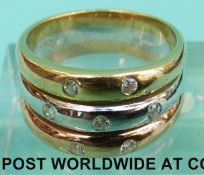A tri-coloured ring marked 585 set with seven diamonds (Size N, 6.
