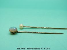 A 9ct gold stick pin set with an opal cabochon and a gold stick pin set with a pearl