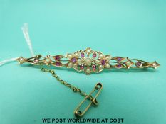A yellow metal bar brooch set with seed pearls and rubies