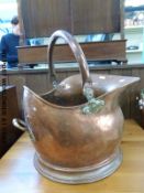 A copper coal scuttle with brass mounts