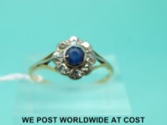 An 18ct gold ring set with a sapphire surrounded by diamonds (size P)