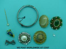 A collection of costume brooches to include an enamel owl and a hallmarked silver bangle