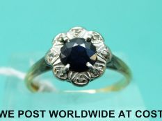 An 18ct gold ring set with a sapphire surrounded by diamonds in a platinum setting (size N)