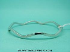 A 9ct white gold bangle in wave design (4.