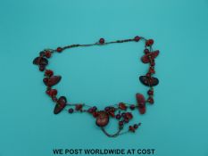 A coral necklace with various spherical and angular beads, 66cm long.