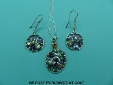 A silver necklace set with multi-coloured sapphires including a blue emerald cut,