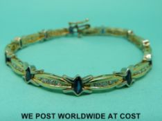 A yellow metal bracelet marked 14k set with marquise cut sapphires and round cut diamonds