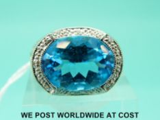 A yellow metal ring marked 14k set with a blue topaz surrounded by diamonds,